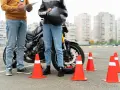 Instructor y alumno junto a moto en circuito de prácticas. Se preguntan: ¿cuánto dura el teórico del A2?