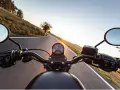 Manillar de moto en carretera al atardecer, listo para el examen de circulación A2.