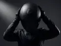 Persona con casco negro y chaqueta de cuero, lista para la carretera. ¿Shoei vs Arai? La elección es tuya.