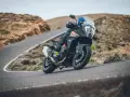 Motociclista en una KTM 1290 Adventure, inclinada en una curva de carretera montañosa. El peso de la moto se siente en la maniobra.