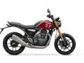 Una moto Triumph roja y gris, un ejemplo de motos neo retro, con horquilla dorada y escape plateado, lista para la aventura.
