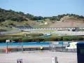 Pista de carreras con gradas y vegetación. Se preparan las instalaciones para la próxima carrera de MotoGP.