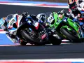 Pilotos compiten en una carrera de superbikes, inclinándose en una curva. ¡Así es donde ver superbikes!