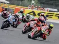 Motociclistas compiten en una carrera, con el número 65 en primer plano. El sbk calendario se acerca.