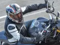 Motociclista con casco Suomy, con diseño llamativo, en una moto deportiva. Las opiniones sobre cascos Suomy son positivas.