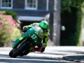 Victor López compite en la Isla de Man con su moto verde número 17, inclinado en una curva cerrada.