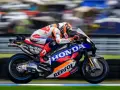 Piloto del Repsol Honda Team en plena carrera, con su moto de competición luciendo los colores icónicos.