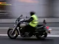Motociclista con chaleco reflectante amarillo brillante, cumpliendo la norma de que es obligatorio llevar chaleco reflectante en la moto.