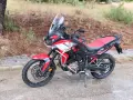 Honda Africa Twin roja y negra, lista para la aventura. Opiniones positivas sobre su rendimiento en todo terreno.