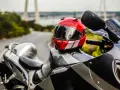 Casco rojo y blanco sobre una moto deportiva. Listo para limpiar interior casco y salir a la carretera.