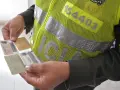 Agente de tránsito revisa documentos. ¡Ay, he perdido los papeles de la moto!