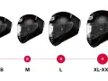 Cuatro cascos de moto negros de diferentes tamaños, etiquetados de XS-S a XL-XXL.