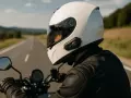 Motociclista con casco blanco y un intercomunicador moto legal, disfrutando de un viaje por carretera.