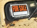 Coche antiguo a la venta, con cartel "FOR SALE". Para saber si una moto tiene cargas, revisa su historial.