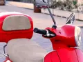 Scooter gran cilindrada rojo brillante, con asiento y maletero a juego. Lista para recorrer la ciudad con estilo.