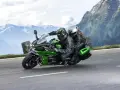 Pareja en una moto deportiva verde y negra, disfrutando de un viaje por carretera entre montañas. ¡Las mejores motos deportivas para aventuras!