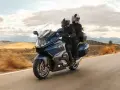 Pareja disfrutando de un viaje en moto cómoda por un paisaje rural.
