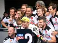 El equipo de Paolo Simoncelli celebra con gestos de victoria.