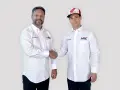 Dos hombres con camisas blancas de Honda y HRC Racing se dan la mano. Uno lleva una gorra de Honda.