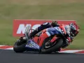 Piloto en moto Honda roja y azul inclinado en curva durante las 8 horas de Suzuka.