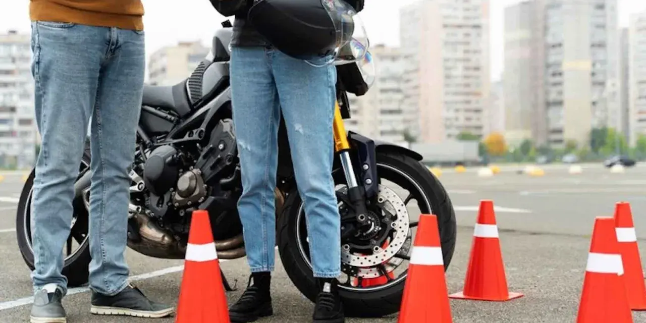 Instructor y alumno junto a moto en circuito de prácticas. Se preguntan: ¿cuánto dura el teórico del A2?