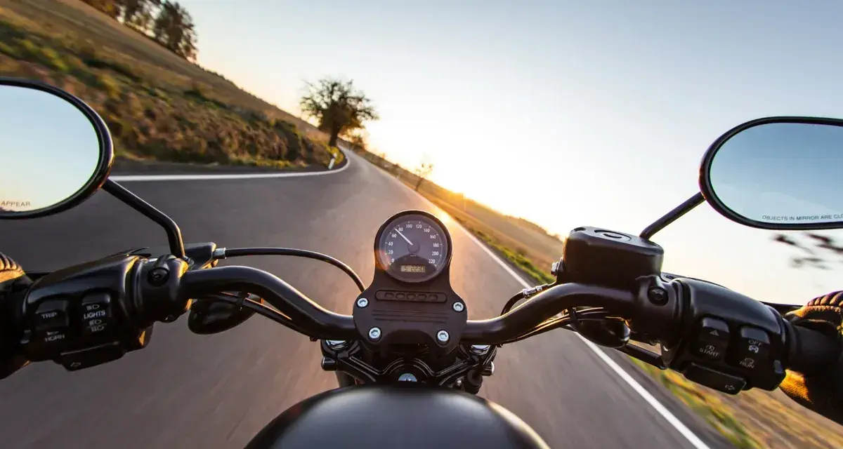Manillar de moto en carretera al atardecer, listo para el examen de circulación A2.