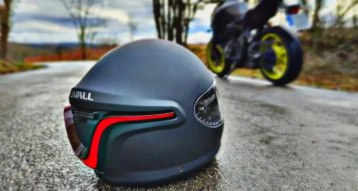 Casco negro mate con luces traseras rojas, listo para la aventura. Los mejores cascos de seguridad para tu moto.