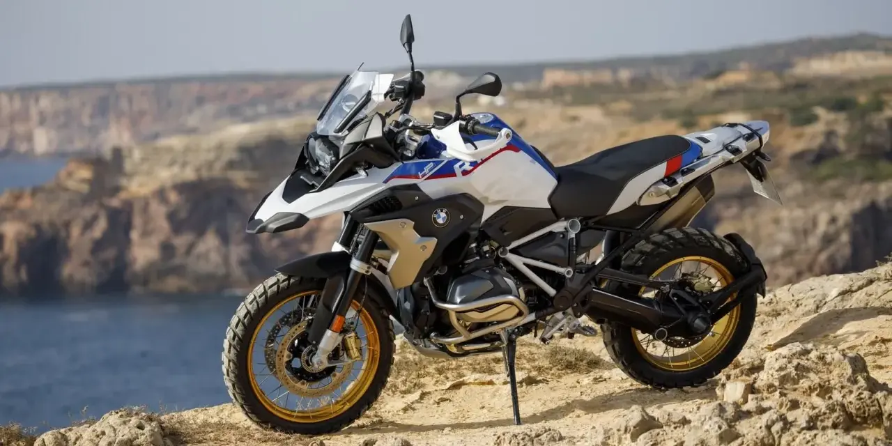 Moto BMW lista para aventuras en trail asfalticas, con vistas al mar y acantilados.