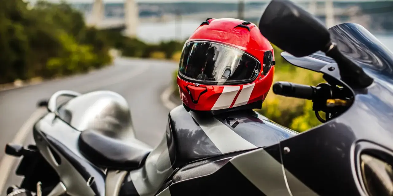 Casco rojo y blanco sobre una moto deportiva. Listo para limpiar interior casco y salir a la carretera.