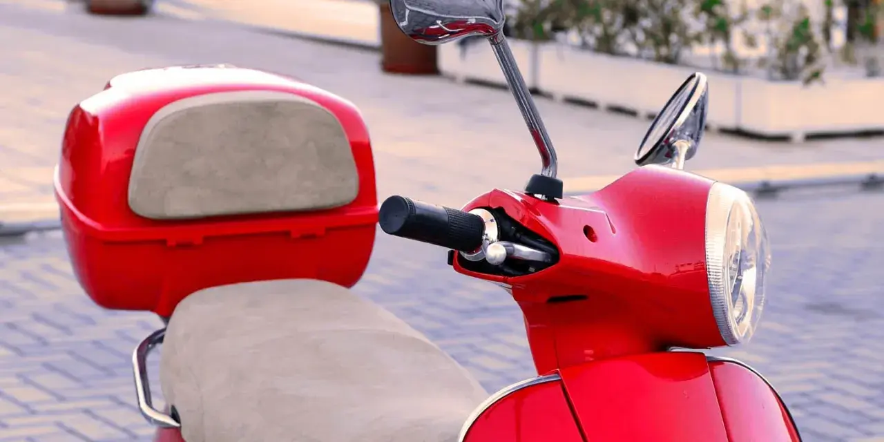 Scooter gran cilindrada rojo brillante, con asiento y maletero a juego. Lista para recorrer la ciudad con estilo.
