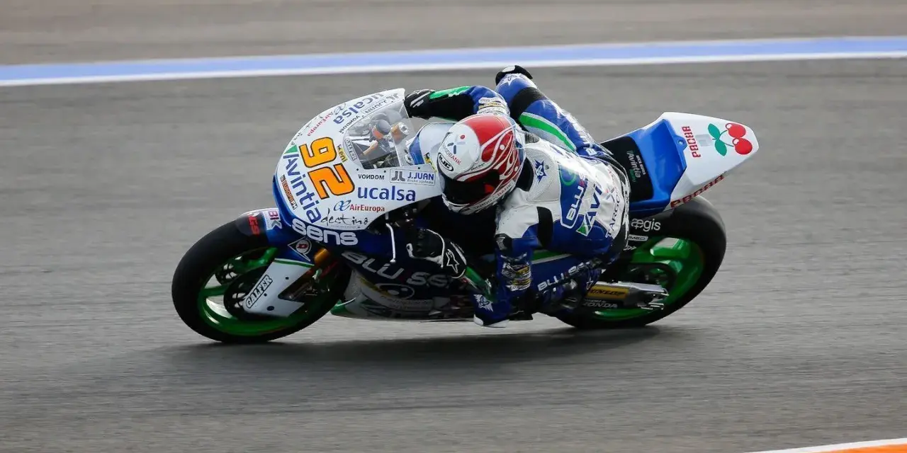 Alex Mariñelarena inclinado en su moto de carreras, con el número 26 y el logo de Avintia, compitiendo en la pista.