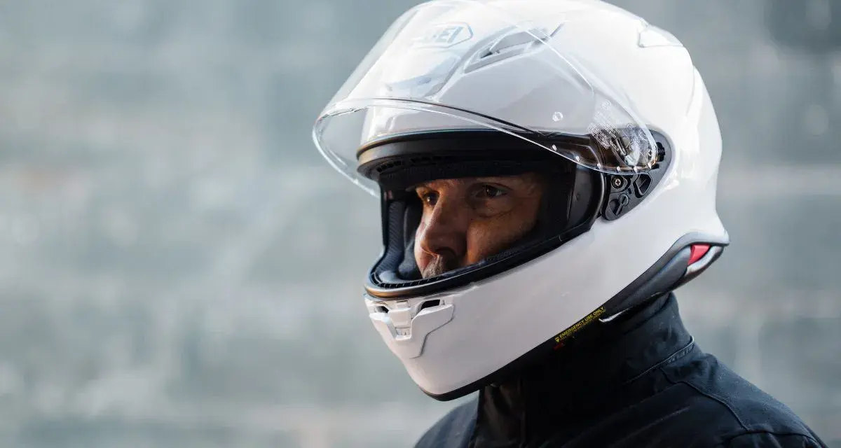 Hombre con casco blanco Shoei NXR 2. Su peso es ideal para largas rutas.