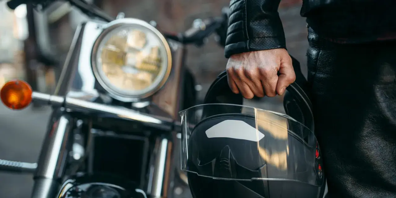 Motociclista con casco, listo para dar de baja una moto sin llevarlo al desguace.