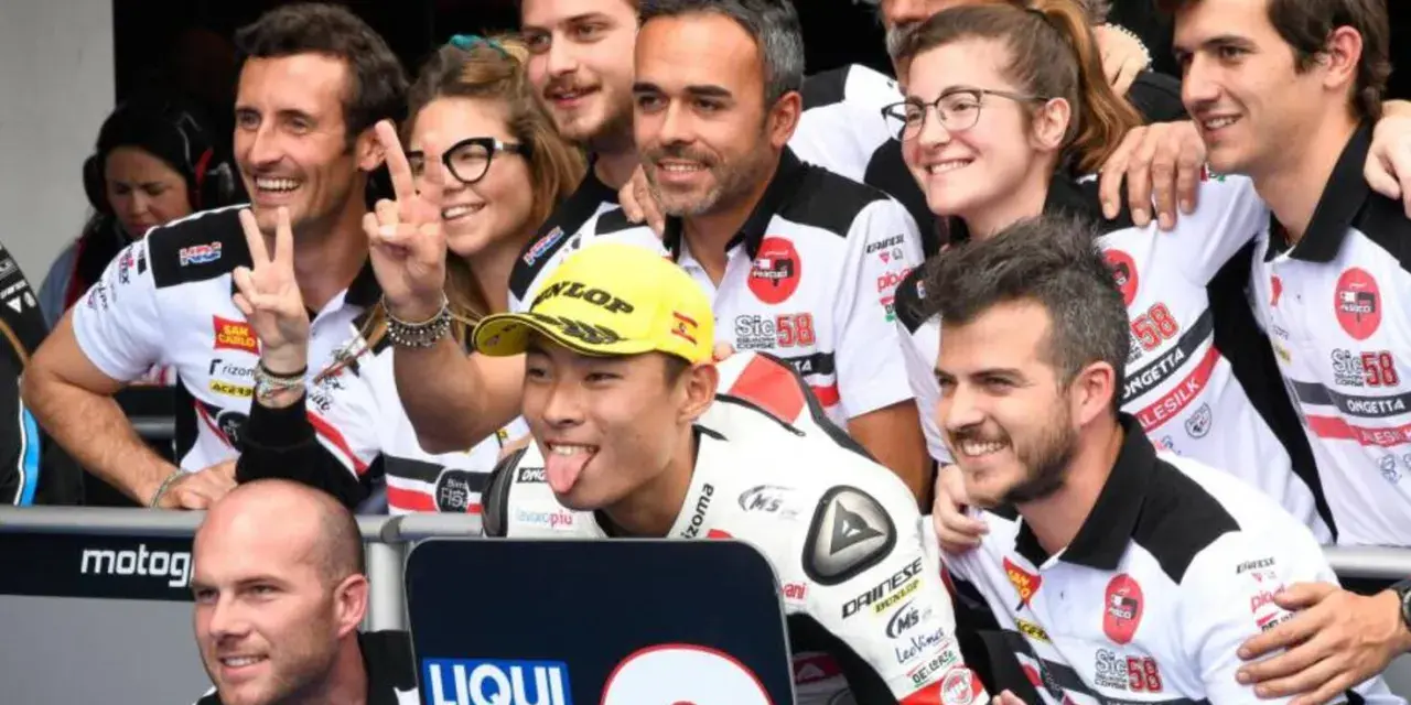 El equipo de Paolo Simoncelli celebra con gestos de victoria.
