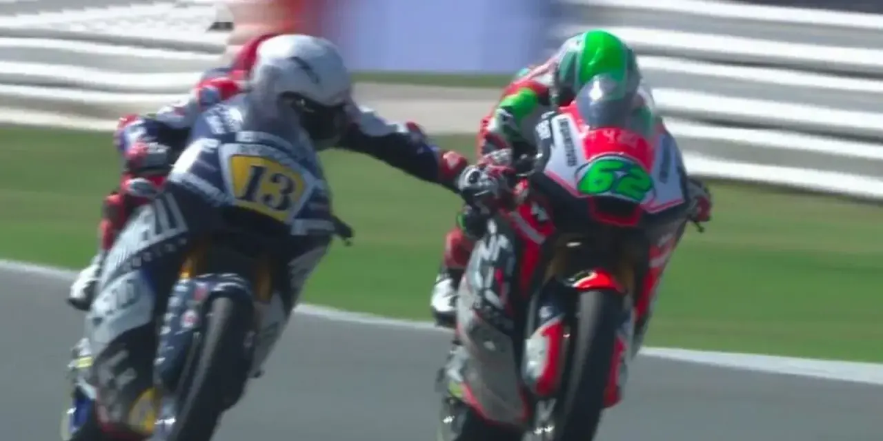 Dos pilotos de MotoGP compiten, uno con el número 13 y el otro con el 62. Romano Fenati, con el 13, intenta adelantar.