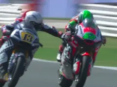 Dos pilotos de MotoGP compiten, uno con el número 13 y el otro con el 62. Romano Fenati, con el 13, intenta adelantar.
