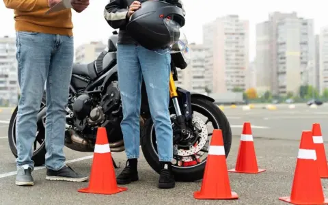 Instructor y alumno junto a moto en circuito de prácticas. Se preguntan: ¿cuánto dura el teórico del A2?
