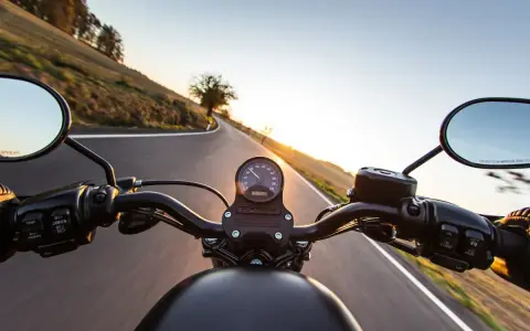 Manillar de moto en carretera al atardecer, listo para el examen de circulación A2.