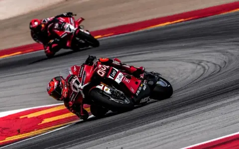 Dos pilotos de superbikes en sus motos rojas toman una curva cerrada. ¡No te pierdas el horario superbikes hoy en Teledeporte!