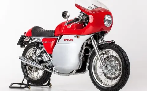 Jawa motos: una moto clásica roja y plateada con carenado, asiento negro y detalles cromados, lista para la carretera.