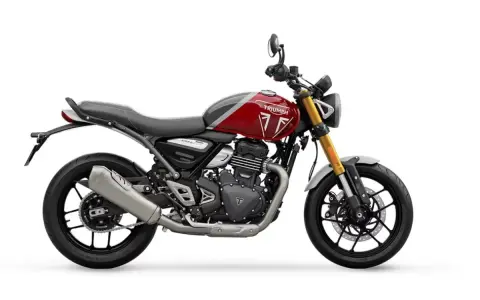 Una moto Triumph roja y gris, un ejemplo de motos neo retro, con horquilla dorada y escape plateado, lista para la aventura.