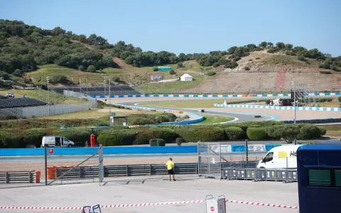 Pista de carreras con gradas y vegetación. Se preparan las instalaciones para la próxima carrera de MotoGP.