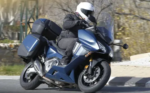Motociclista en Honda Forza 750 azul con maletas, ideal para viajes. Conoce su honda forza 750 ficha técnica.
