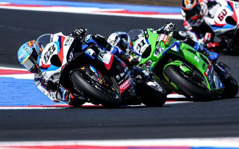 Pilotos compiten en una carrera de superbikes, inclinándose en una curva. ¡Así es donde ver superbikes!