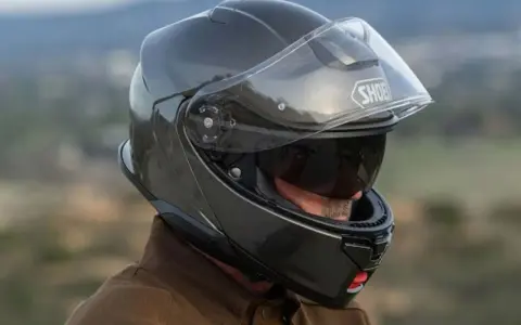 Hombre con casco touring silencioso, listo para un viaje tranquilo.