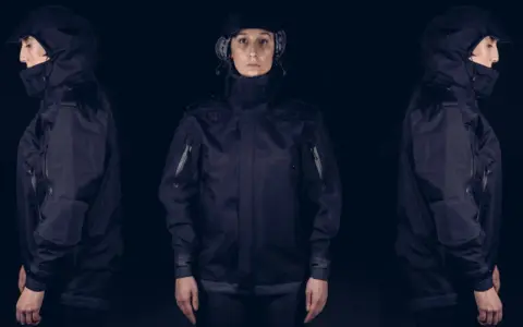 Tres vistas de una mujer con una chaqueta moto miline negra, con capucha y detalles técnicos.
