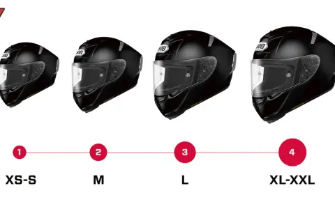 Cuatro cascos de moto negros de diferentes tamaños, etiquetados de XS-S a XL-XXL.