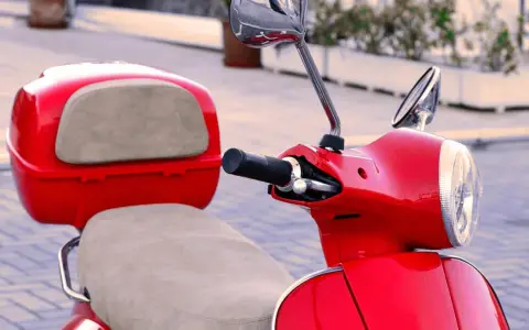 Scooter gran cilindrada rojo brillante, con asiento y maletero a juego. Lista para recorrer la ciudad con estilo.
