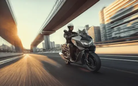 Hombre en moto moderna, ideal para **motos para principiantes**, circulando por una autopista urbana al atardecer.