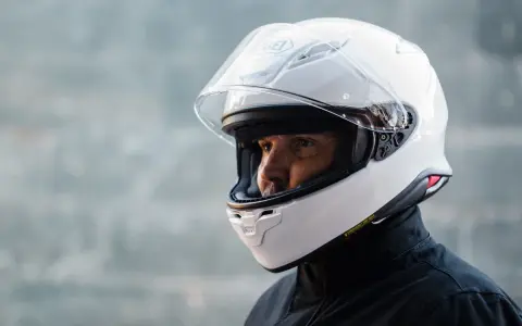 Hombre con casco blanco Shoei NXR 2. Su peso es ideal para largas rutas.